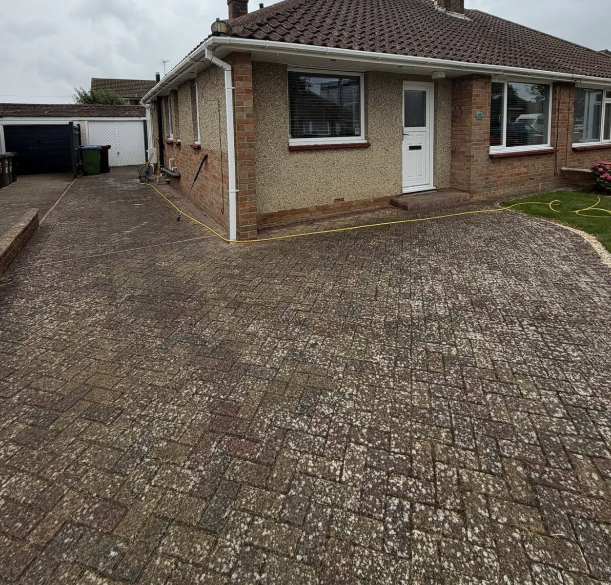 Block paving driveway stained with algae before cleaning